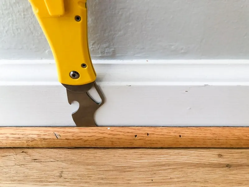 putty knife between quarter round and baseboards