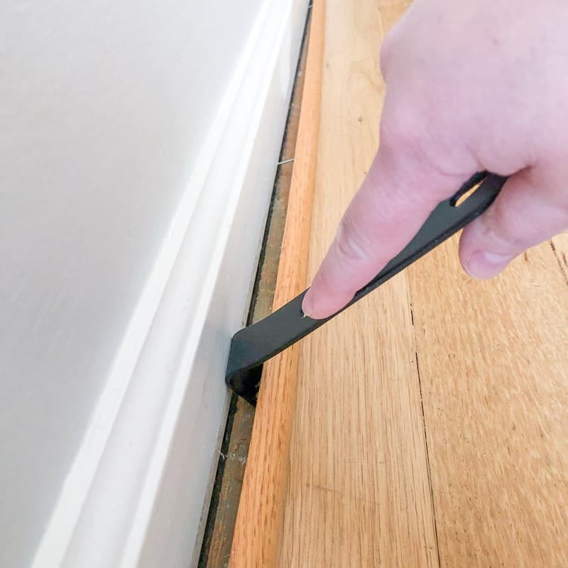 prying quarter round trim loose from baseboards with a small pry bar