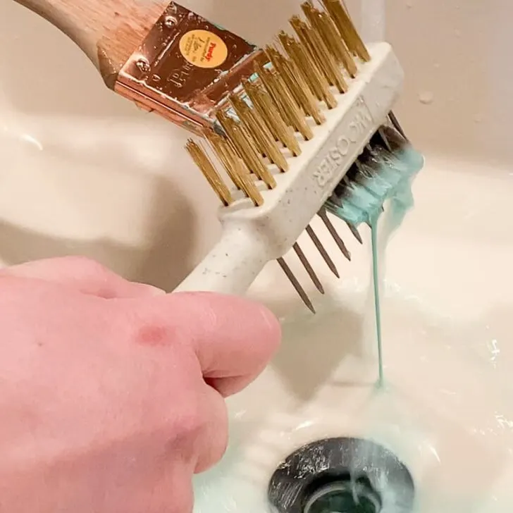 cleaning bristles of paint brush with a comb