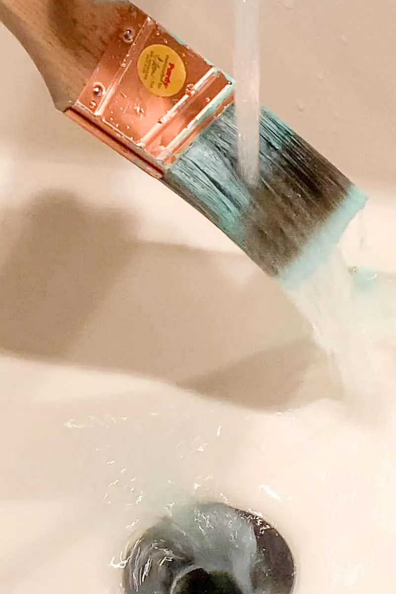 rinsing paint brush in running water