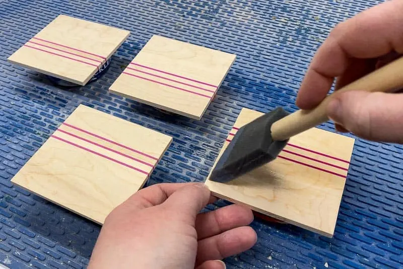 applying polycrylic finish to DIY wood coasters with a foam brush