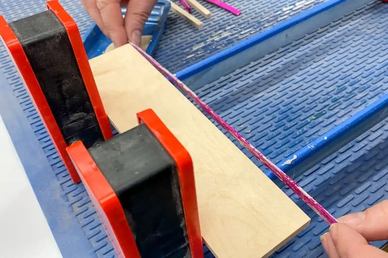adding pink wood veneer stripe to DIY wood coasters during glue up