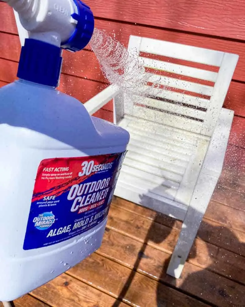 spraying cleaner on outdoor furniture