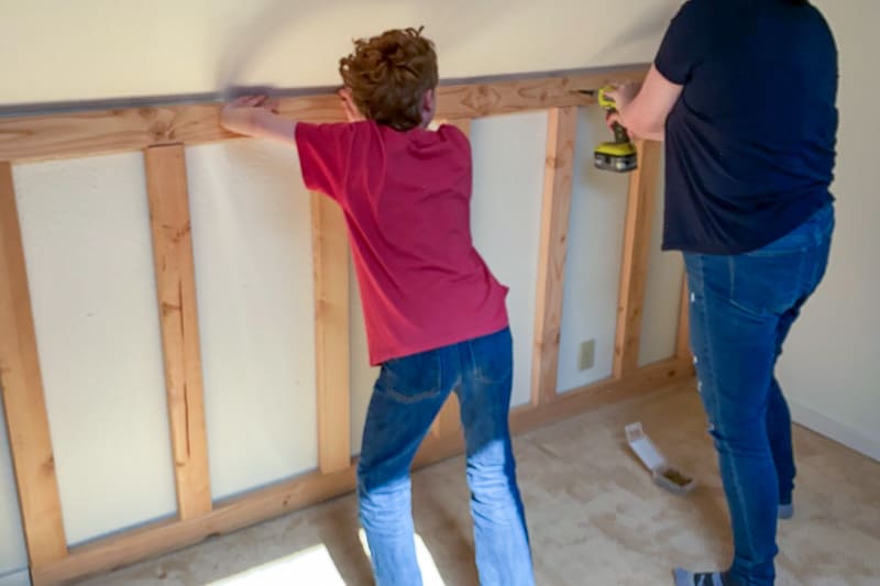 attaching the climbing wall frame to the wall at the studs