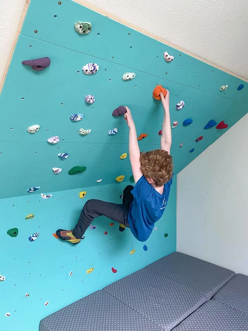 kid hanging on home climbing wall