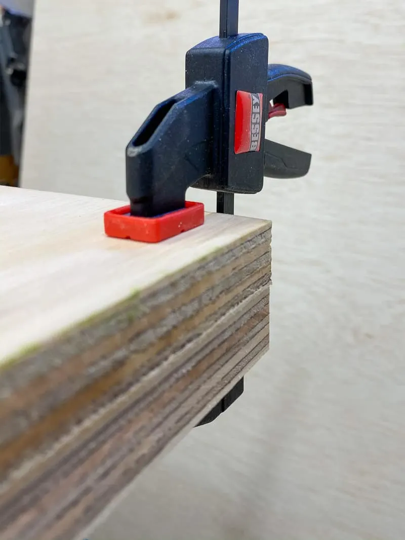 clamp holding two sheets of plywood together