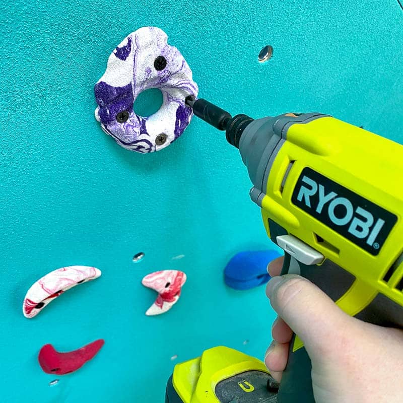 screwing climbing hold into DIY climbing wall