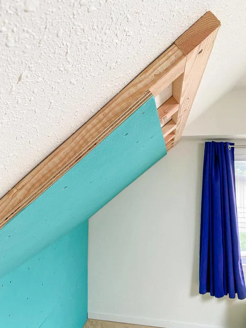 Climbing wall attached to wall and ceiling of sloped attic room