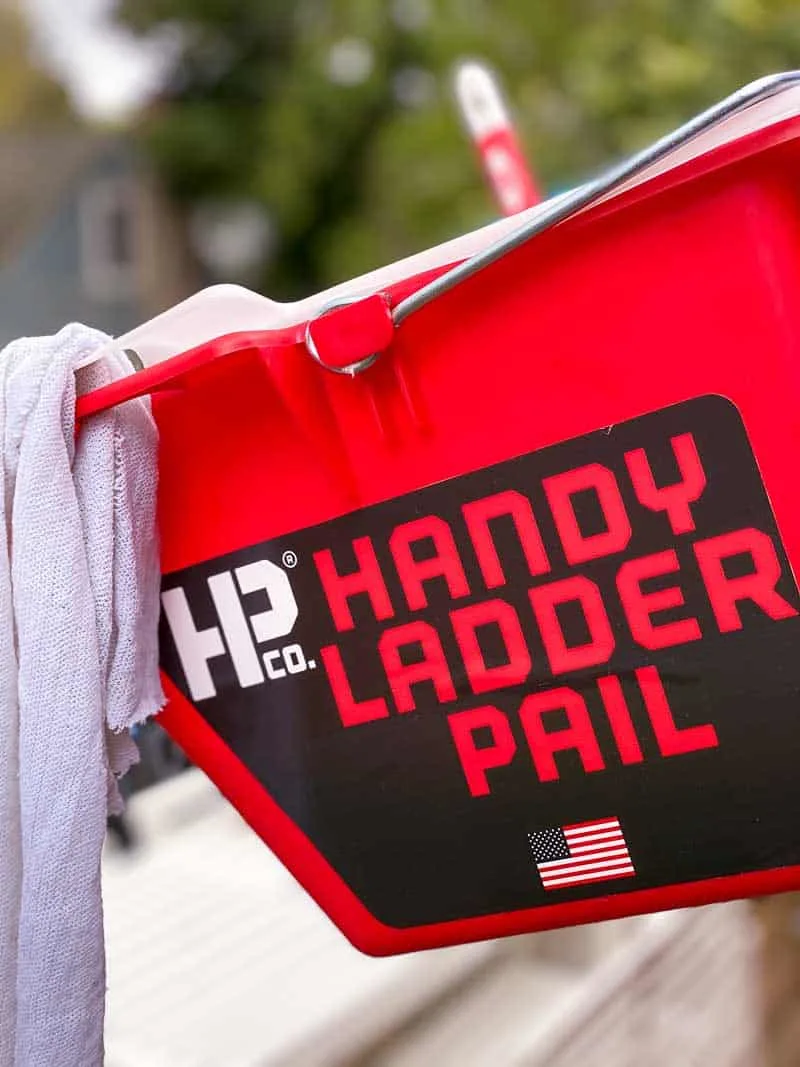 Handy Ladder Pail with rag and paint brush on ladder