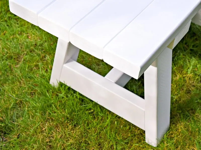 close up of white 2x4 bench on grass