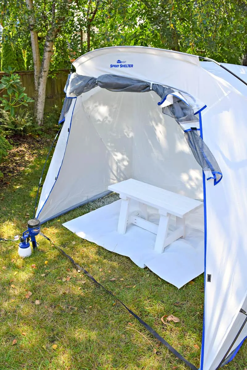 spray shelter set up in backyard for painting a DIY farmhouse bench