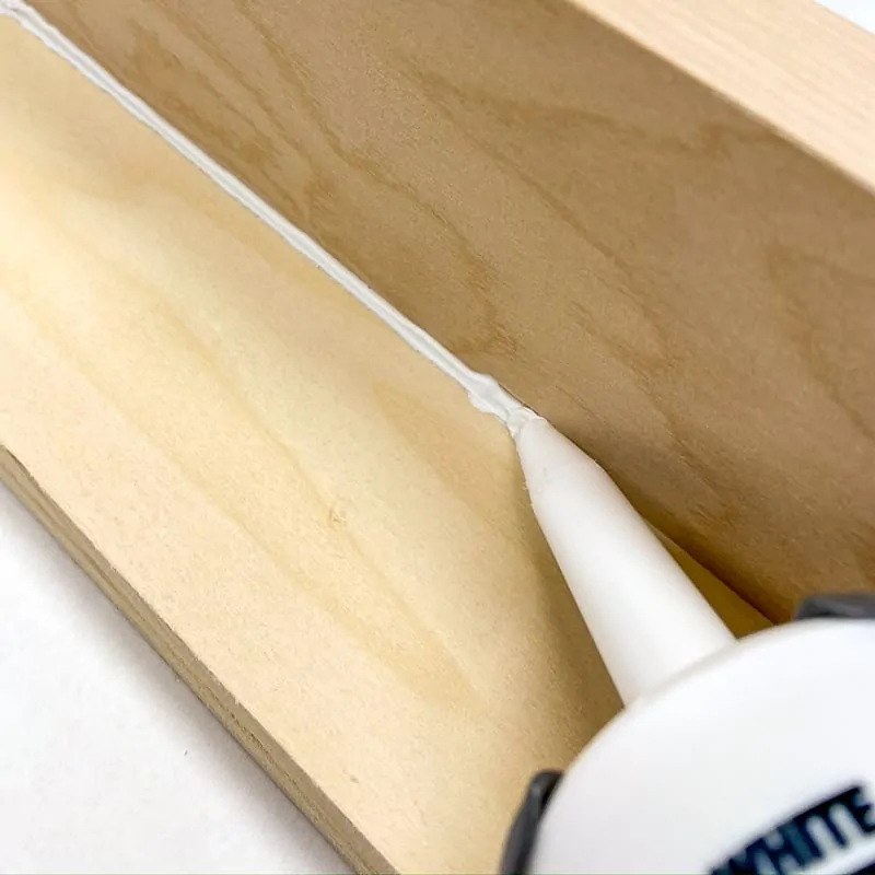 running a bead of caulk down the seam between two perpendicular boards