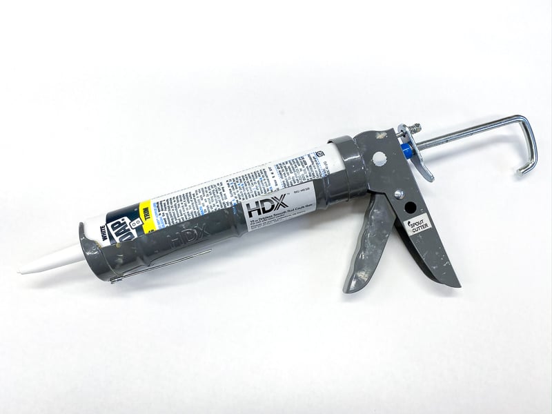 caulk gun with tube of caulk inserted