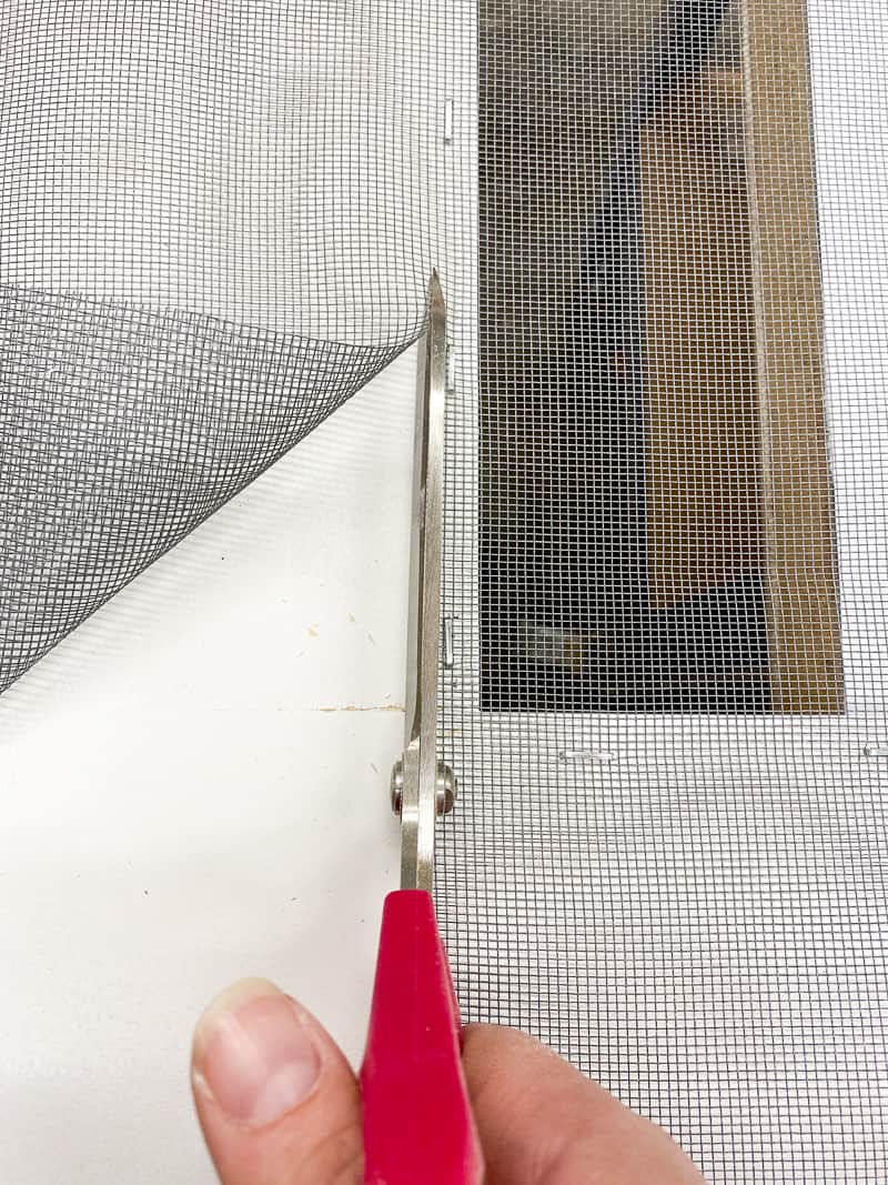 cutting away excess mesh from DIY screen door