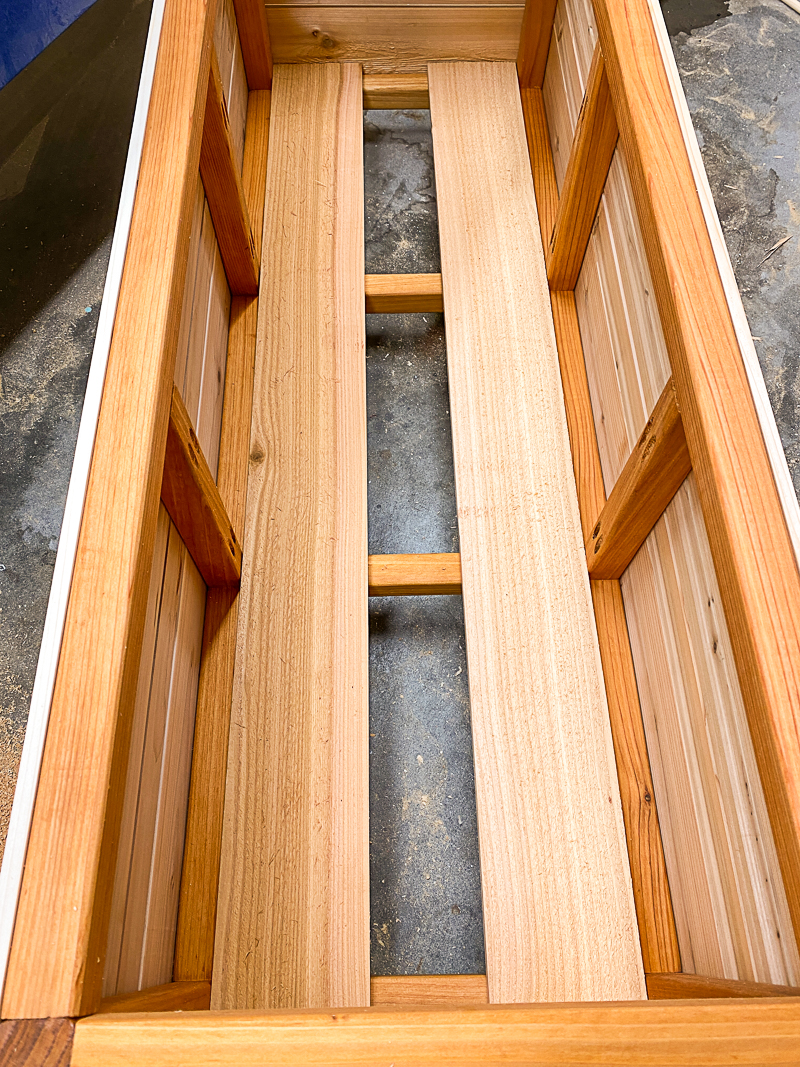 two slats in bottom of DIY outdoor storage box with gap in the middle