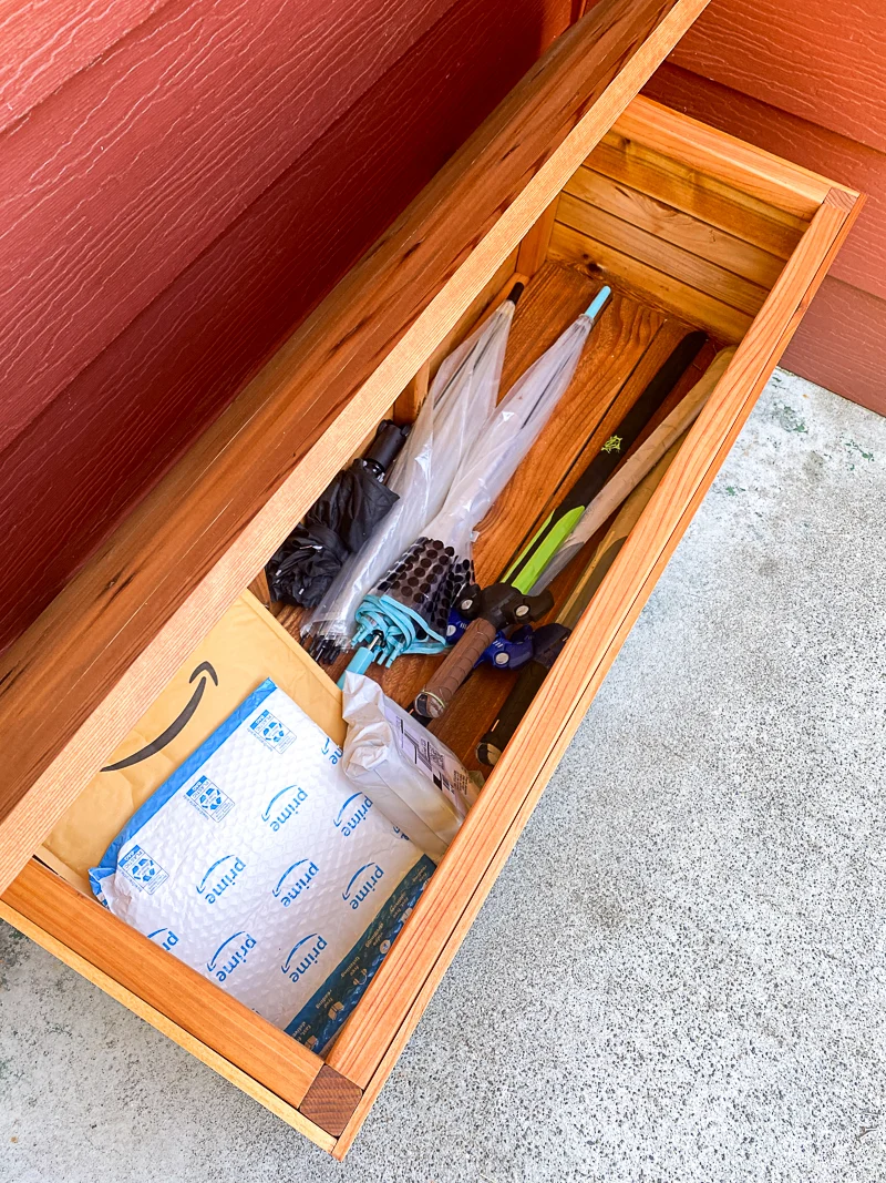 packages hidden on front porch inside DIY outdoor storage box