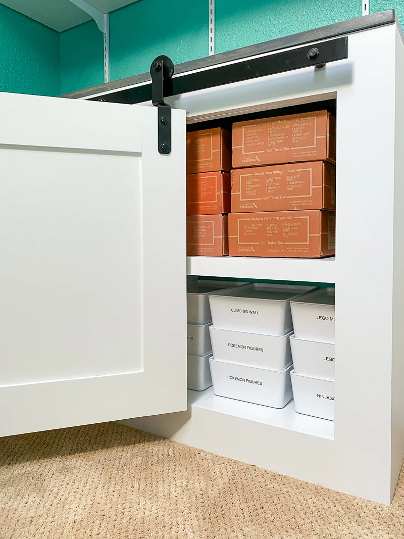 bifold barn doors partially opened to reveal organized bins inside cabinet