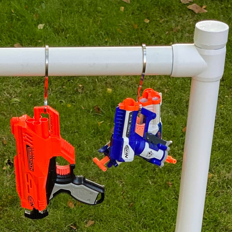 Nerf guns on hooks hanging from storage rack