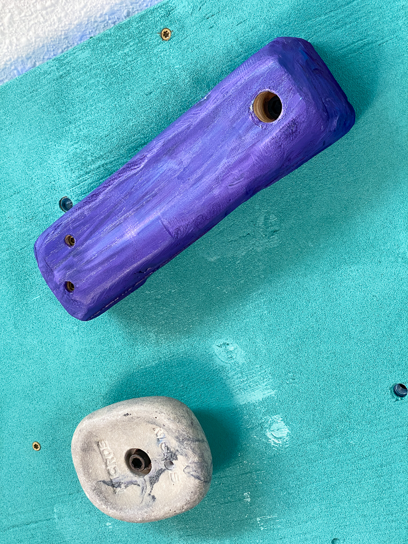 wooden climbing hold shaped like a telephone on DIY climbing wall