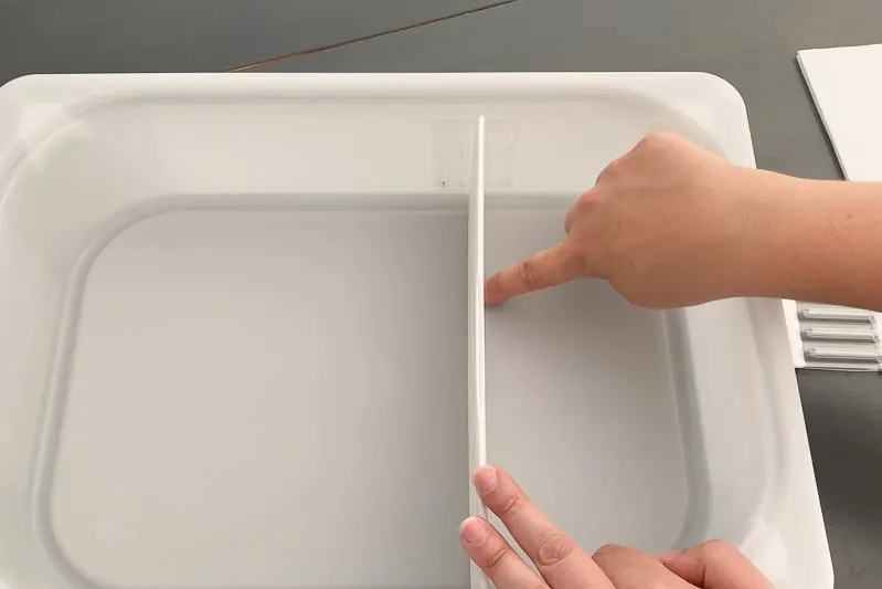 Line up the drawer divider with the markings on the bottom of the drawer