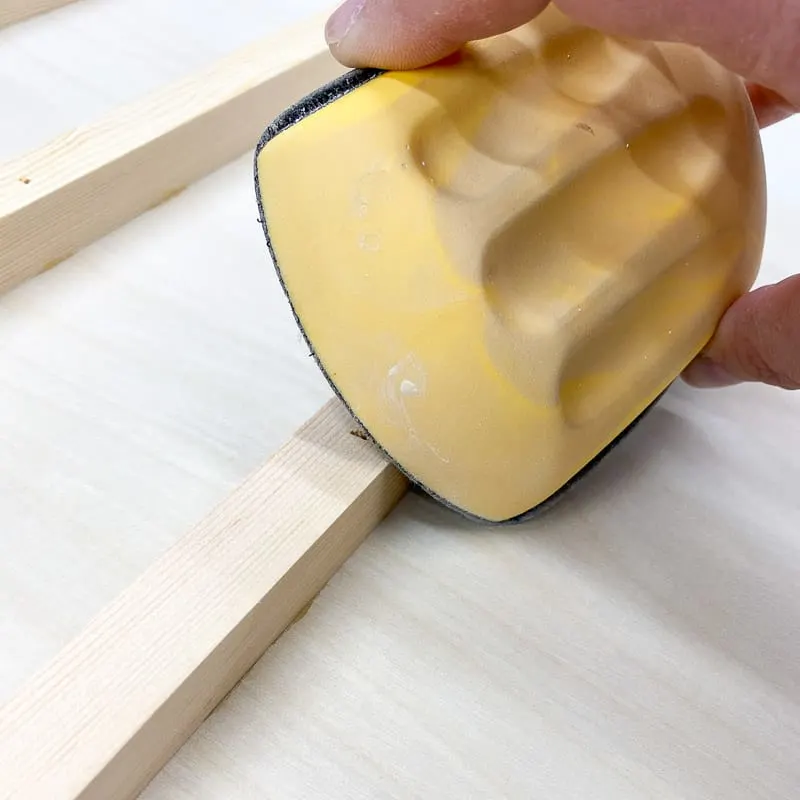 using a sanding block to break the sharp corners on wood