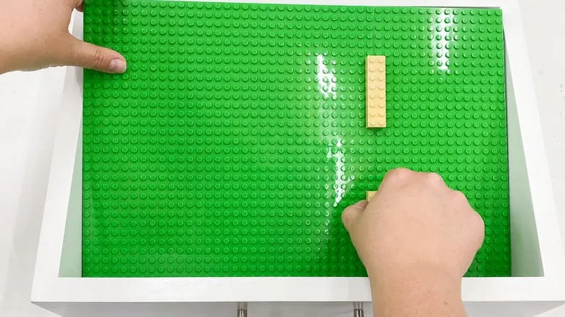 inserting base plates into bottom of Lego tray