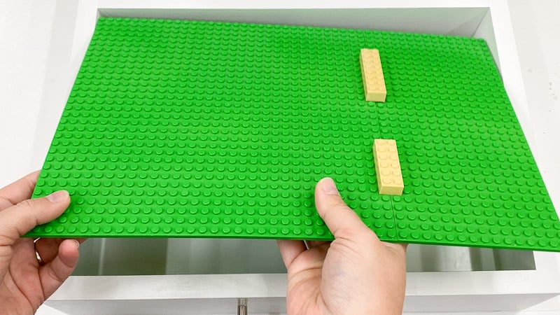 Large Lego pieces connecting two green base plates together