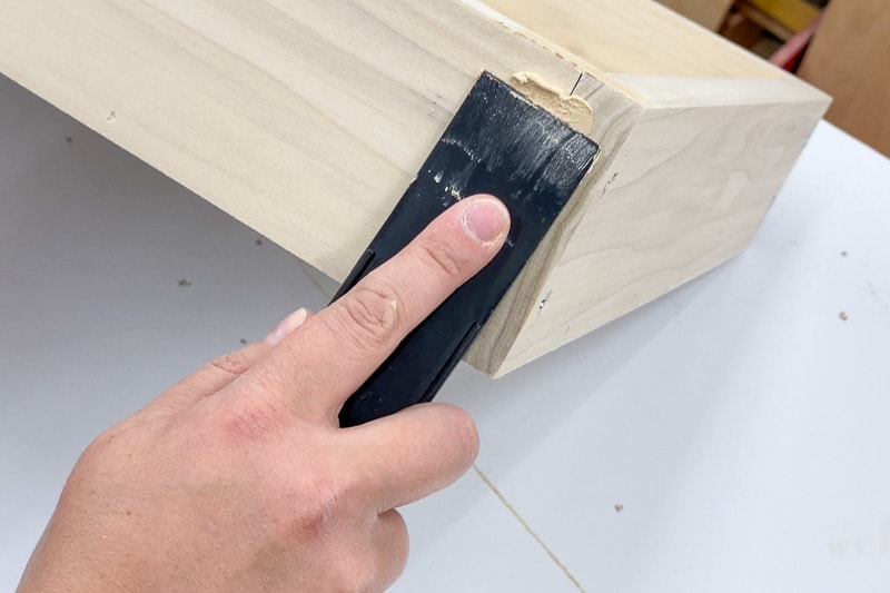 applying wood filler to hole