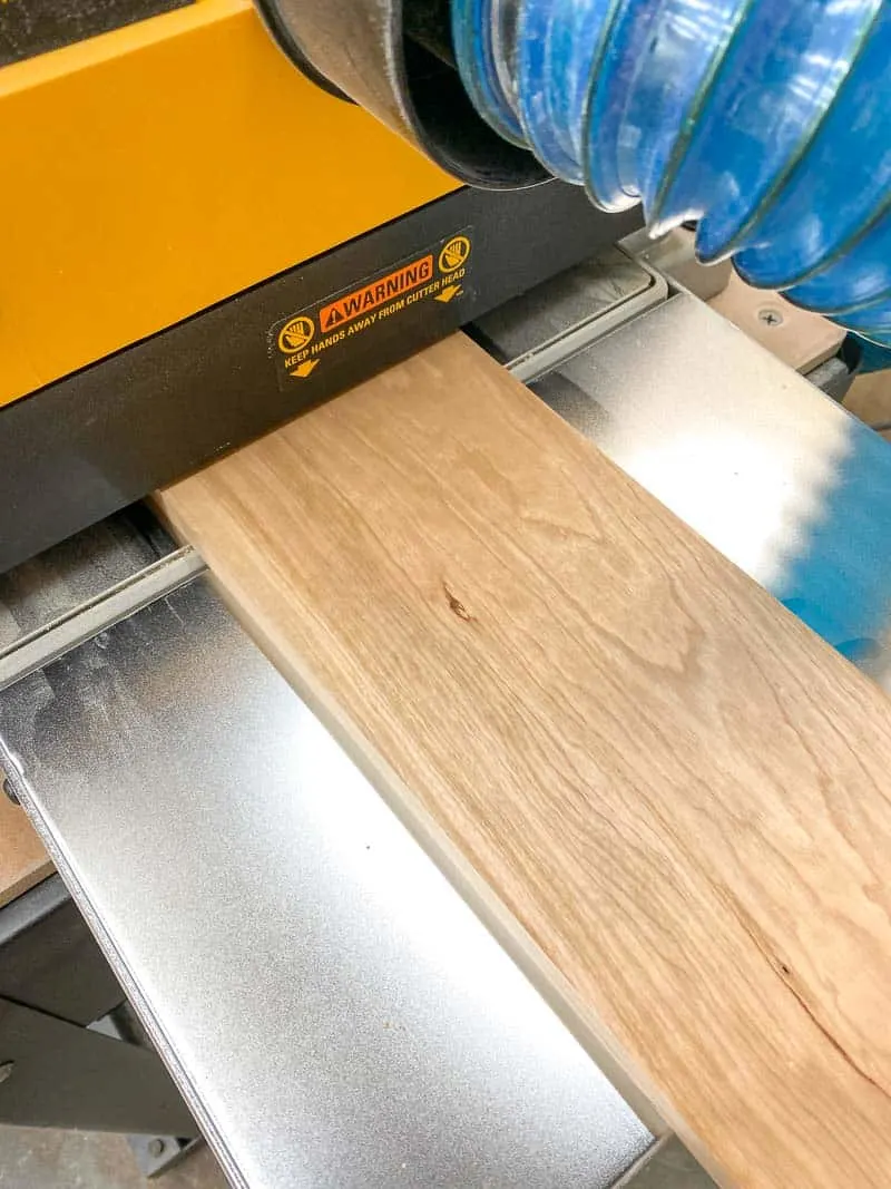 cherry wood board coming out of Dewalt thickness planer