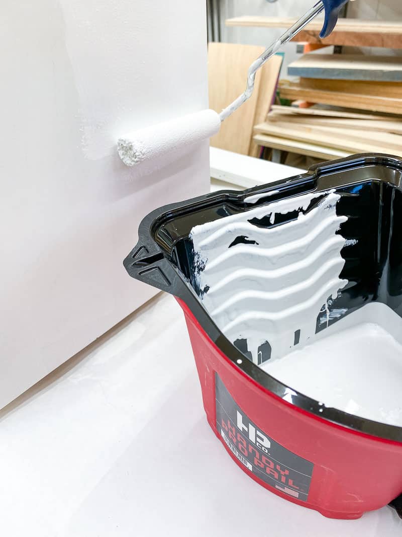 painting sides of wall mount storage bin frame with a roller