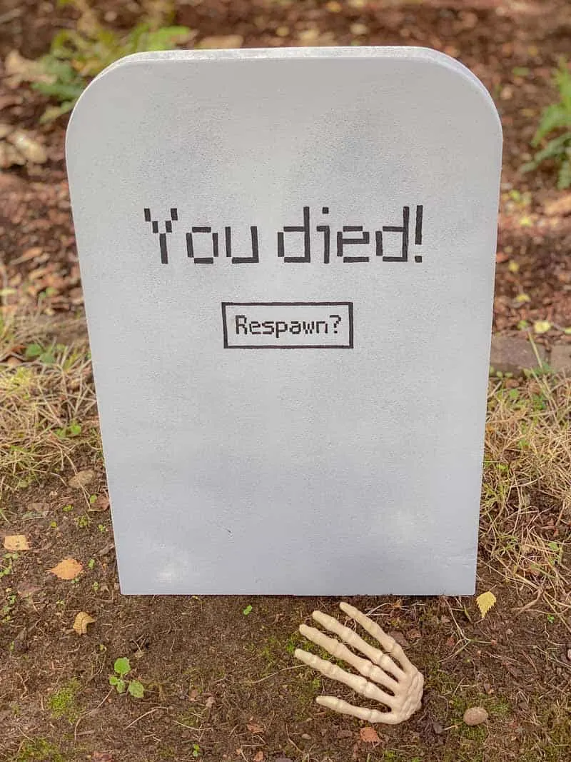 DIY Halloween tombstone with fake skeleton hand coming out of grave