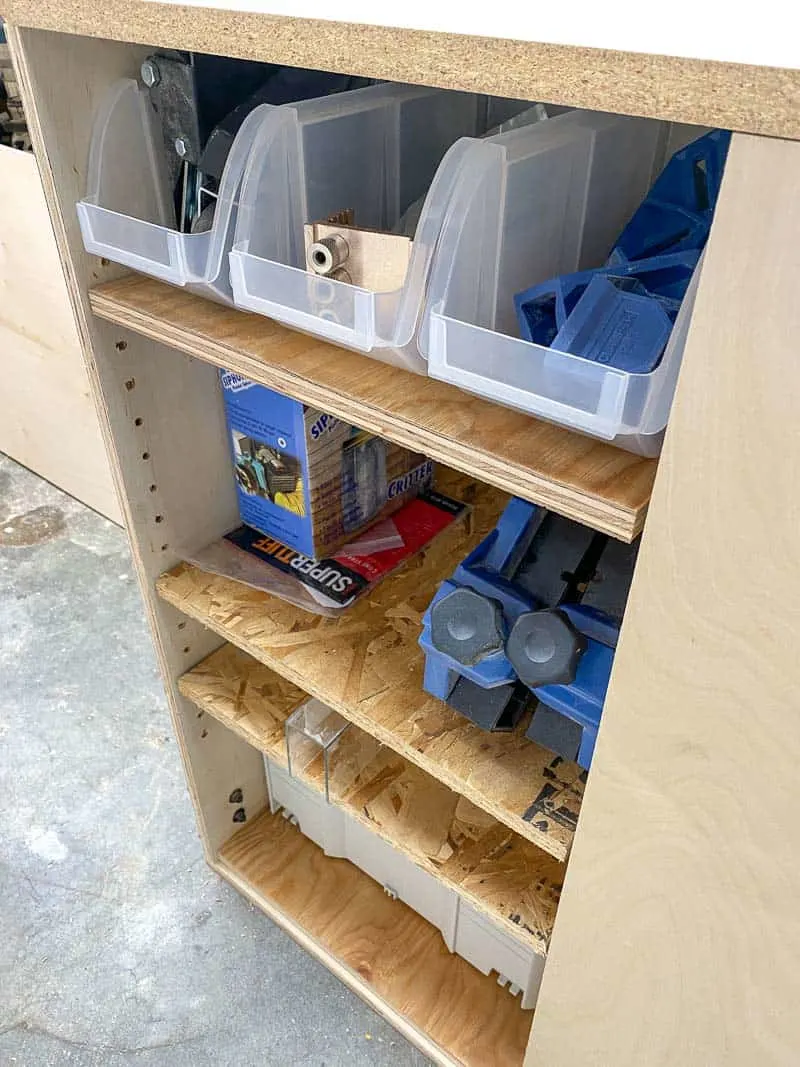 woodworking tools stored on shelves in table saw stand