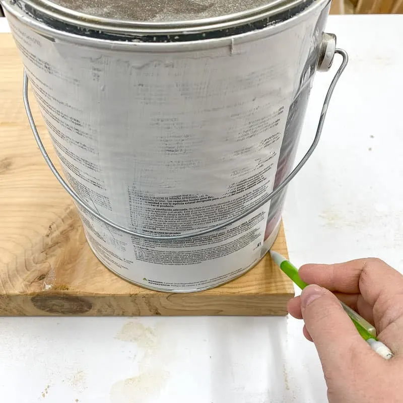 tracing rounded corners onto scrap wood with a paint can