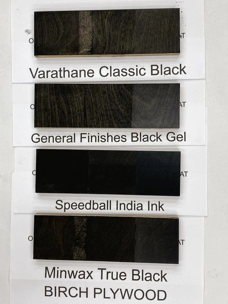 four black wood stain samples on birch plywood