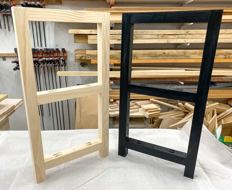 black frame next to natural frame on workbench