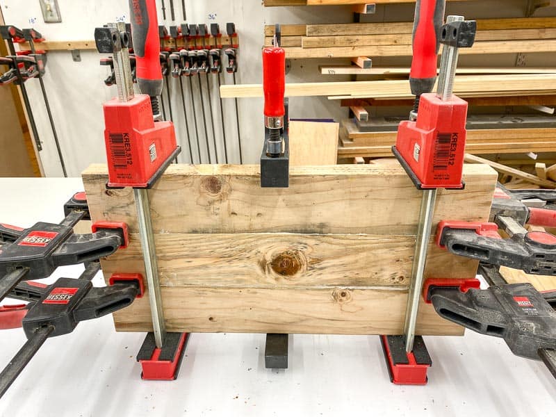 DIY rustic end table shelf glued together and sitting in clamps