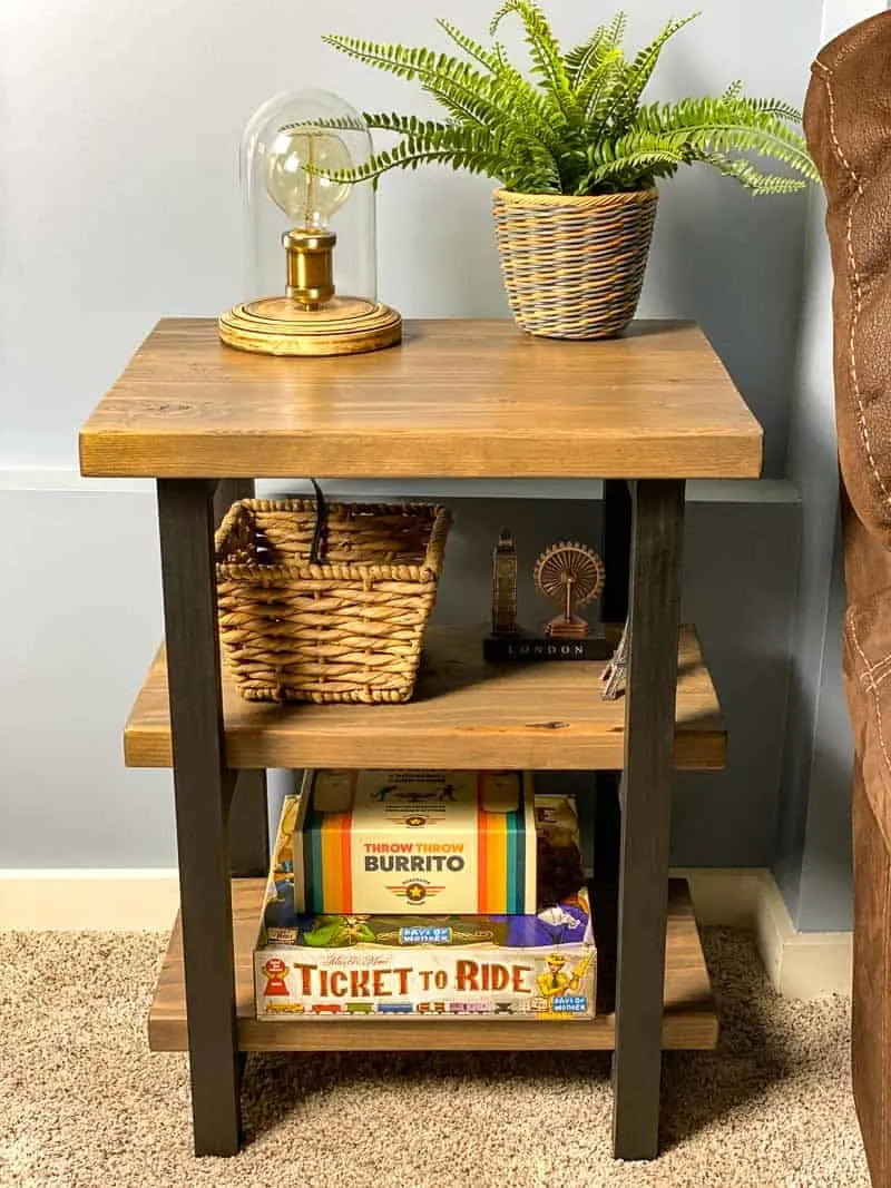 DIY rustic end table with shelves filled with baskets and board games
