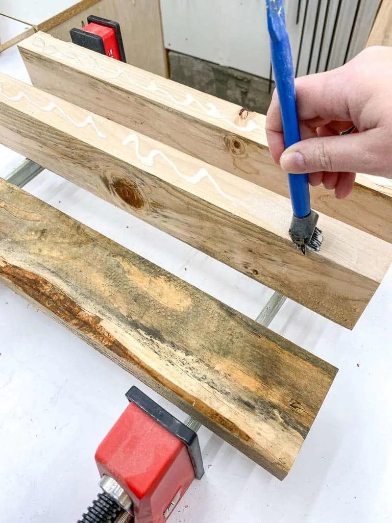 applying wood glue to the cut edge of the 2x4 board