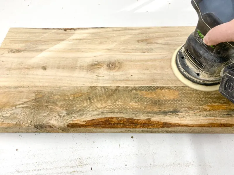 sanding the surface of the rustic end table shelves