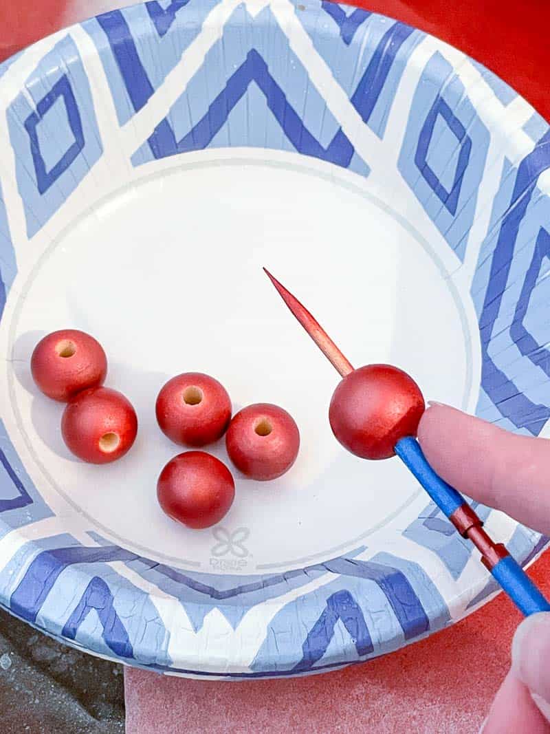 removing wood bead from skewer into bowl