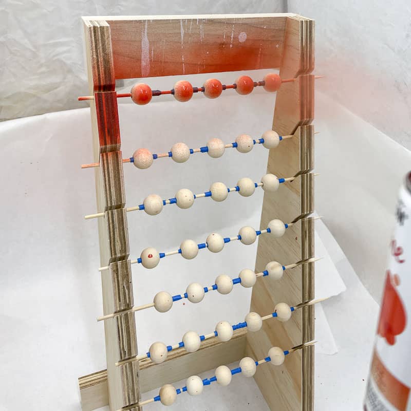 spray painting beads on rack