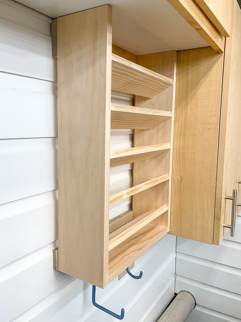 empty spray paint storage rack next to cabinet in workshop