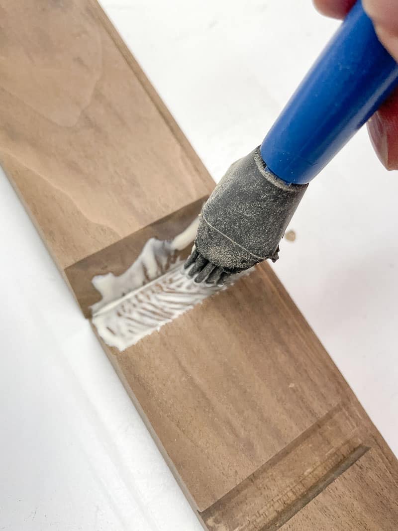 applying wood glue to mitered joint with a glue brush