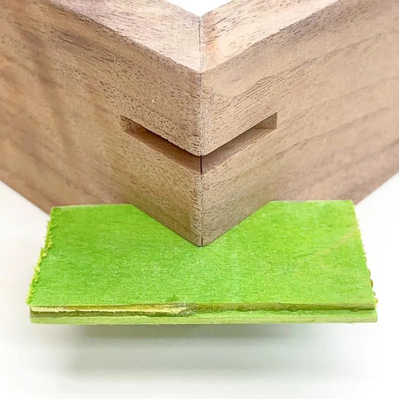 green wood veneer inserted into cut grooves in corners for splines