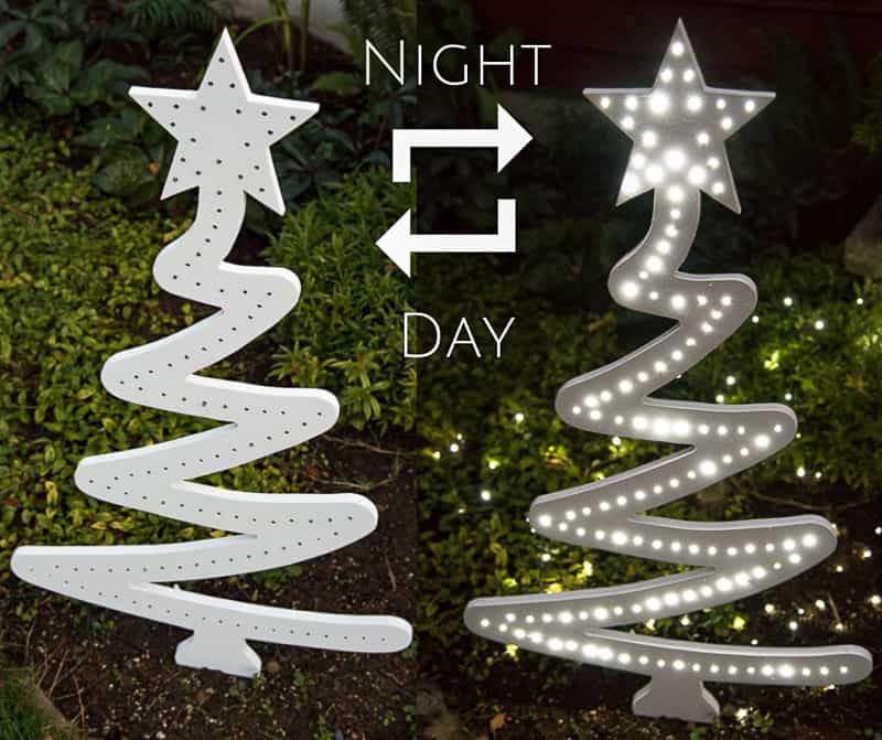 DIY wooden Christmas tree in yard during day and lit up at night