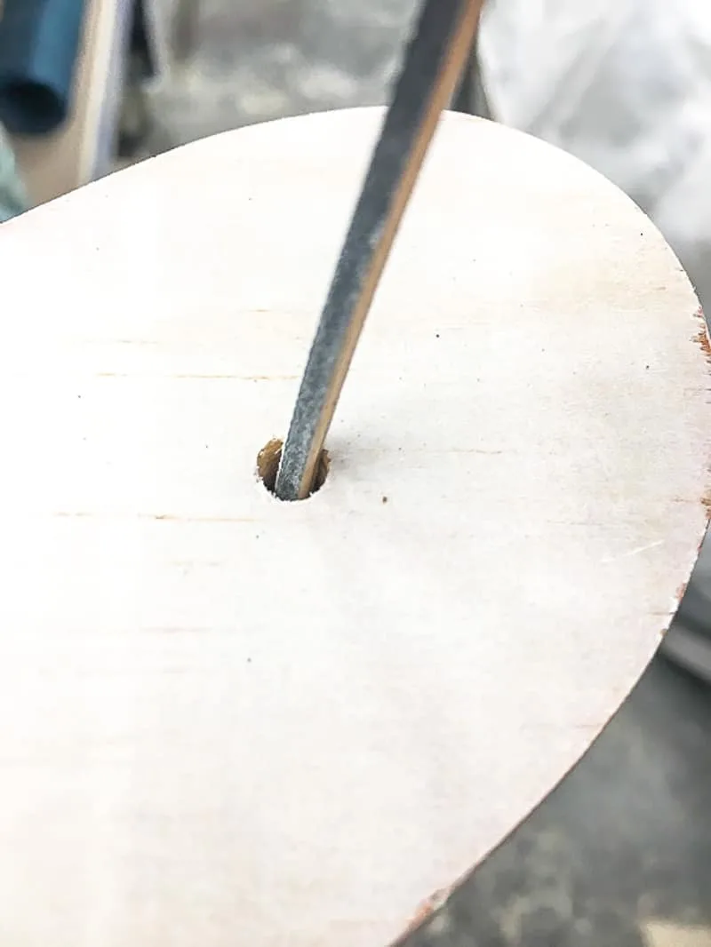 sanding holes for Christmas lights in a wooden Christmas tree with a sanding stick