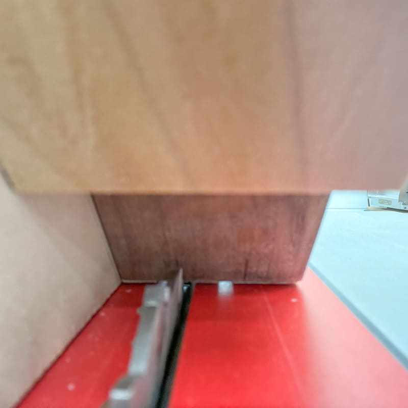 Lining up the table saw blade with the marks on the side of the box in the spline jig