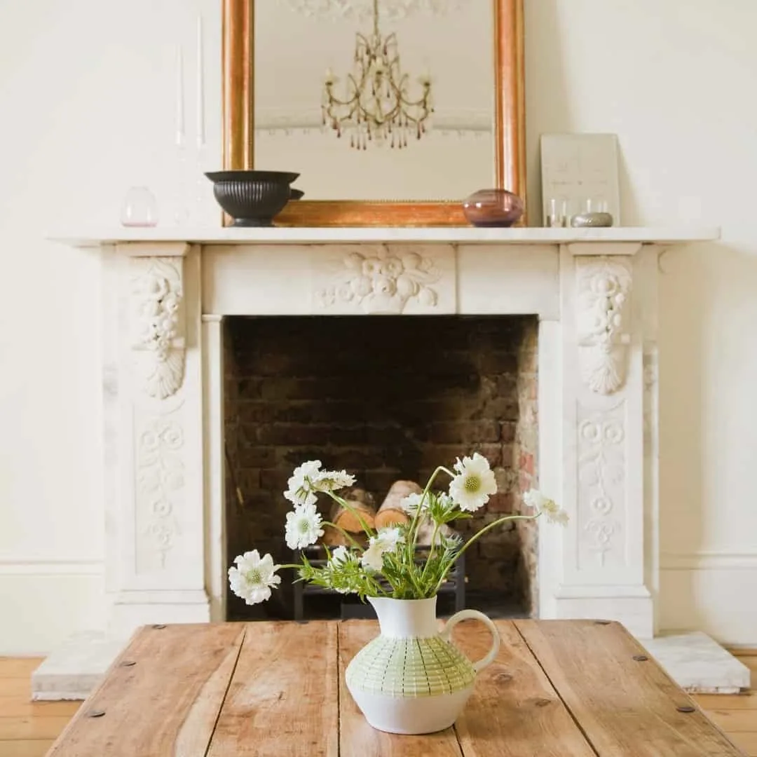 contrasting styles with ornate fireplace and farmhouse table