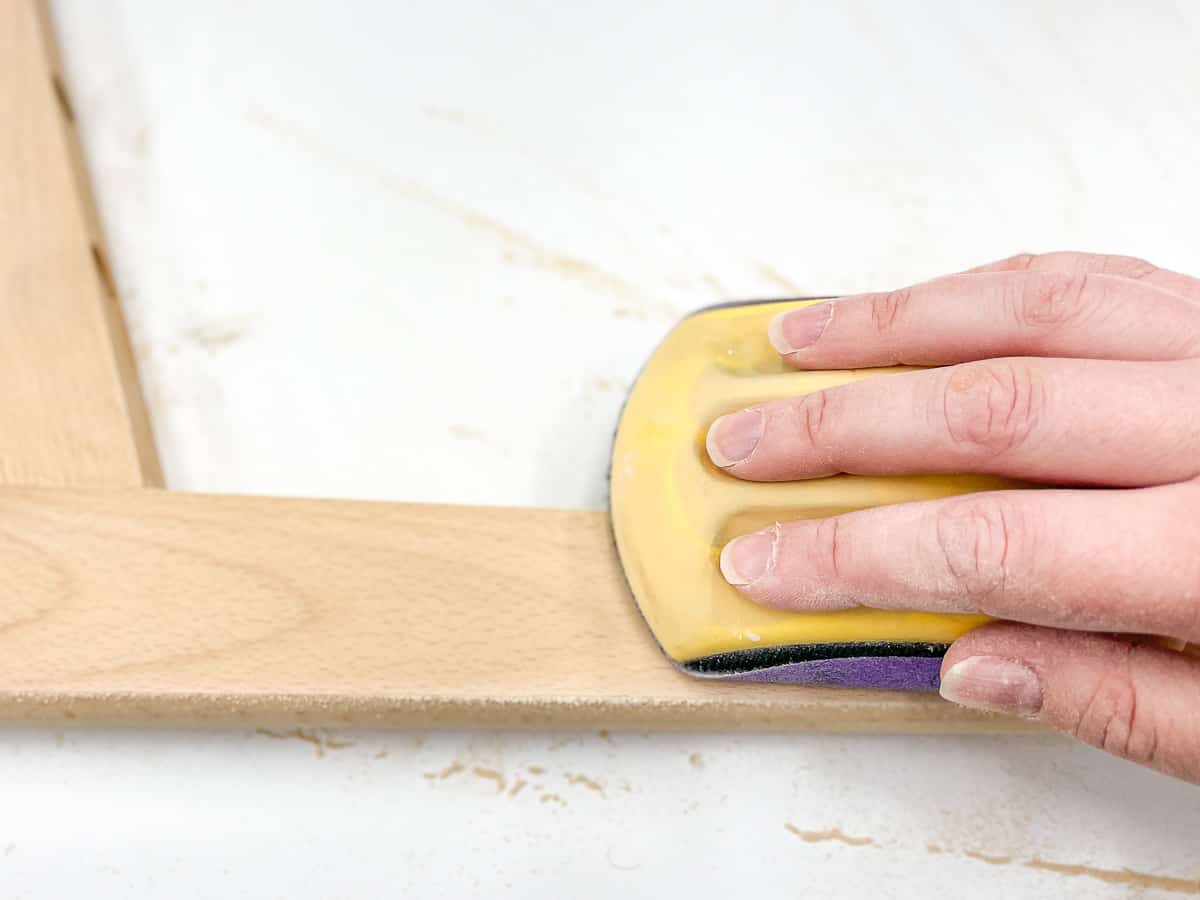 sanding the clear finish off chair legs before applying metallic paint