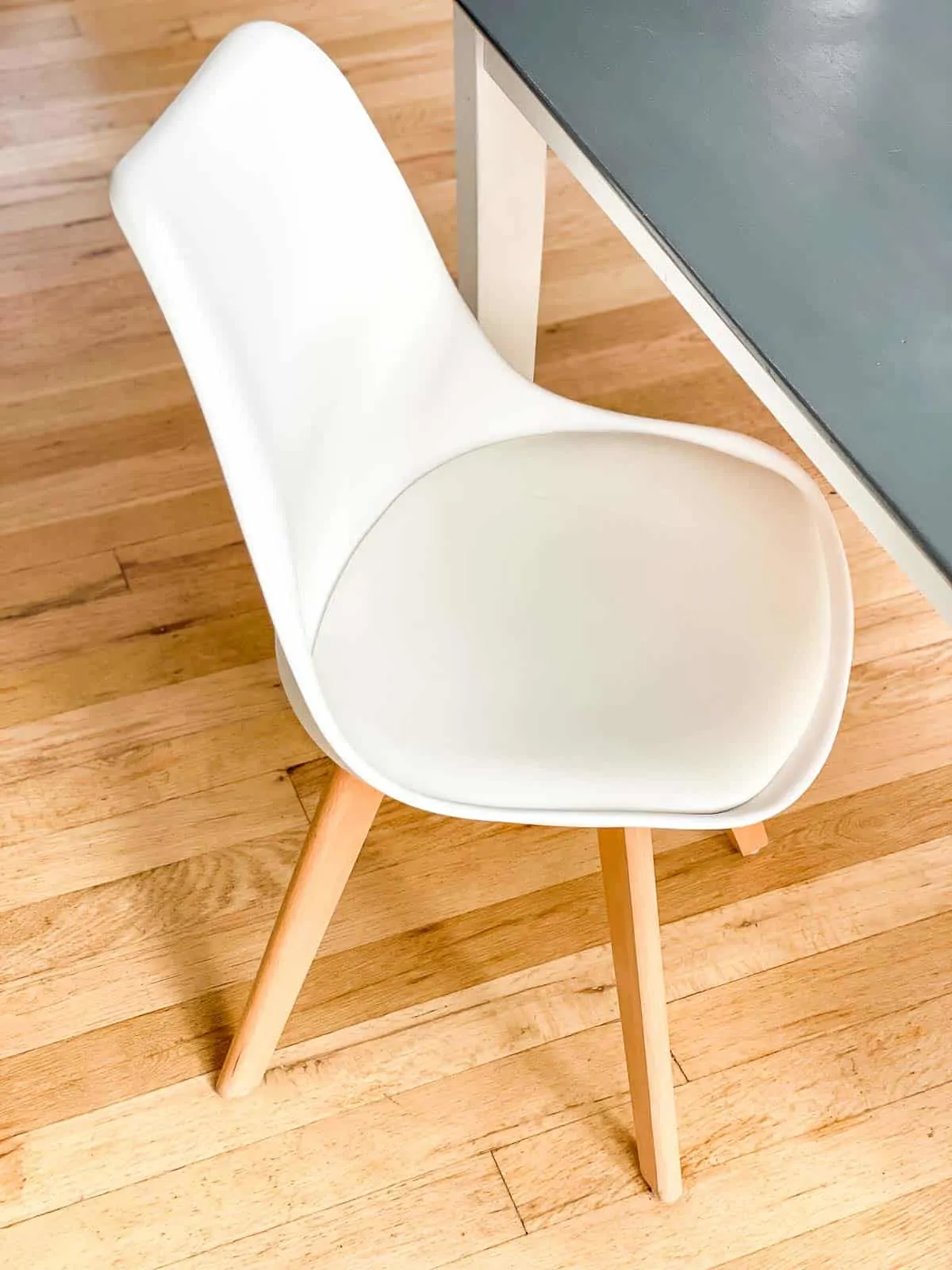 white midcentury modern tulip chair next to gray wood table